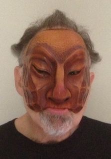 Newman modelling a handcrafted leather Dell'Arte mask: Zanni